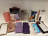 View of all smartphone cases and screen protector laid out showing variety of styles and conditions