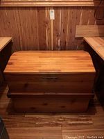 Full front view of handcrafted oval cedar chest showing closed lid and body with natural cedar wood finish.