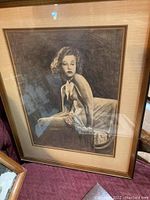 Framed print of nude woman seated, looking sideways, monochrome artwork, frame with beige mat, 16x20 size