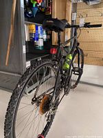 Rear view of bicycle showing knobby tires, rear derailleur, gear cogs and reflector