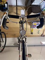 Front view of handlebars with brake levers, black handlebar tape, and front reflector.