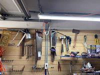 Wide shot showing five hand saws, two mallets, an electric circular saw, a multi-function tool, and hand tools on pegboard.