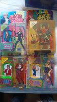 Five Austin Powers figures still in unopened packaging displayed laid out on flat surface