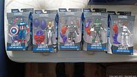 Five Marvel Legends Captain America and Agents of S.H.I.E.L.D. action figures in packaging laid on bed showing full lot