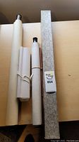 Four Chinese scrolls, three rolled and one mounted, displaying traditional hand painted art.