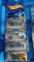 Front view of four unopened Hot Wheels cars in original packaging, showing car details and Hot Wheels branding.