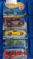 Four Hot Wheels cars in original packaging, stacked vertically showing car designs and packaging details.