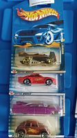 Four unopened Hot Wheels cars in original packaging showing front view of all cars stacked vertically.