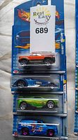 Four Hot Wheels cars in original sealed blister packs showing front and side views with distinct colors and detailed designs.