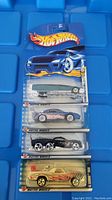 Five unopened Hot Wheels cars in blister pack with flame Hot Wheels logo on the card