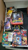 Photo showing an opened box with The Rocketeer booster box prominently visible along with various movie and superhero-themed card packs including Doomsday and Spiderman