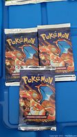 Front view showing three sealed booster packs arranged on blue surface