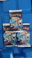 Five unopened booster packs arranged on blue background