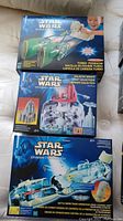Three boxed Star Wars Episode I collectible toys: Turbo Podracer, Galactic Senate playset, and Trade Federation Droid Control Ship with droid figures.