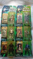 Nine Star Wars Power of the Jedi action figures unopened in blister packs featuring various characters.