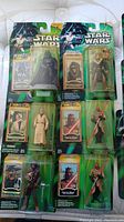 Overview image showing eight Star Wars Power of the Jedi figures in original packaging including Darth Vader, Obi-Wan Kenobi, Chewbacca, Darth Maul, and others.
