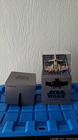 Front and back view of the Star Wars T-65 X-Wing battling drone in packaging and display stand.