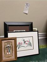 Five framed prints arranged on floor against a wall showing the assortment of indigenous and nature themed art.