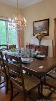 Dining room table set with table and chairs shown with decorative items on the table, overview of lot contents.