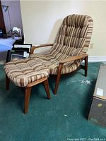 Front view of teak armchair and ottoman showing overall appearance and upholstery