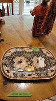 Full view of rectangular handpainted platter with intricate patterns on wooden table.