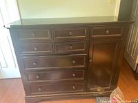 Front view of wood dresser showing all drawers and cabinet door closed