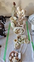 Wide view of statues and onyx decorative items arranged on a flat surface with green tape borders