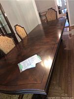 Full view of extended dining table with chairs behind