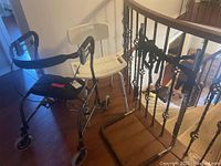 Walker, shower chair, and bed rail displayed together near staircase