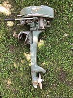 Side view of green Elgin outboard motor showing throttle handle and mounting bracket.