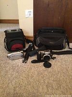 Lot overview showing two camcorders, tripod, and two camera bags