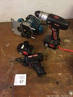Craftsman cordless drill with battery, charger and Makita router on wooden surface.