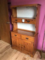 Full view of two-piece wood hutch showing upper shelf, drawers, and lower cabinet doors