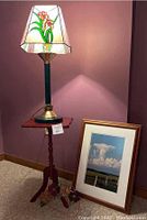 Full view of the lamp on the small side table with framed photo on floor