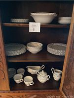 Overall view of the Myott Trousseau fine ironstone set displayed on shelves with various plates, bowls, cups, sugar bowl, creamer, and gravy boat.