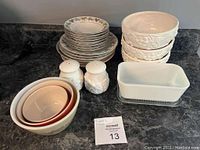 Overview of all dishes, bowls, plates, and salt and pepper shakers on a kitchen counter.