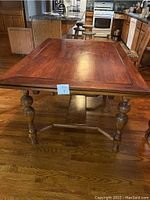 Full view of the wooden table showing the top surface and turned legs.