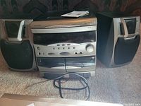 Full view of Koss HH 976 stereo system with left and right speakers placed on carpeted floor showing front-facing controls and speakers.