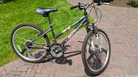 Side view of the black Nakamura 24 inch mountain bike showing overall frame and tires.