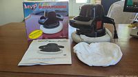 Buffer polisher unit with attached power cord, spare washable pad, user manual, and original retail box displayed on tabletop.