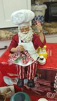 Ceramic Santa shelf sitter with chef hat, candy cane, and apron sitting on original box