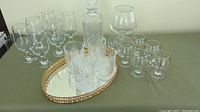 Overview of the collection showing all glasses, decanter with stopper and decorative tray on a table.