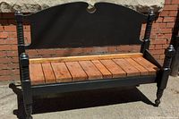 Front view of the solid wood deacon's bench showing black painted headboard and footboard with natural wood slatted seat