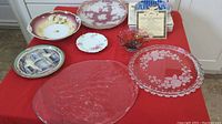 Overview of assorted platters and plates arranged on a red cloth.