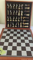Full view of chessboard with animal-themed chess pieces arranged inside a storage compartment above.