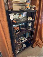 Full view of the wooden bookcase filled with various decorative items to show overall structure, finish, and shelf arrangement.