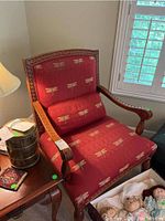 Front angle showing entire chair, highlighting carved arms and dragonfly upholstered cushions with matching lumbar pillow.