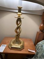 Side view of the twisted brass lamp base on wood surface