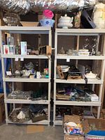 Front view of two Keter plastic shelving units filled with various household items (not included). Both are five-tier shelves, light gray plastic.