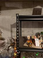 Close-up view of the shelving unit frame showing perforated metal vertical support with some items on shelf (not included)